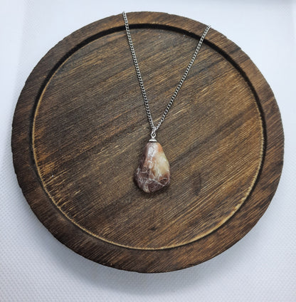 Silver colored necklace with brown natural stone